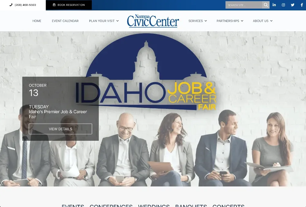Six professionals in suits sit in a row before a banner reading Idaho Job & Career Fair, with a Nampa Civic Center dome