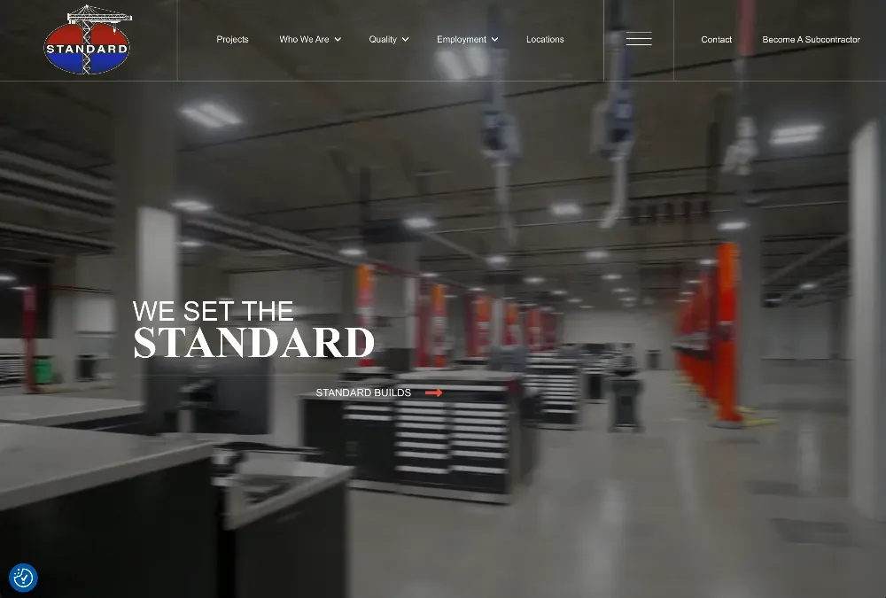 Large unfinished building interior with concrete floors, exposed ceiling ducts, and orange safety posts, with overlaid text